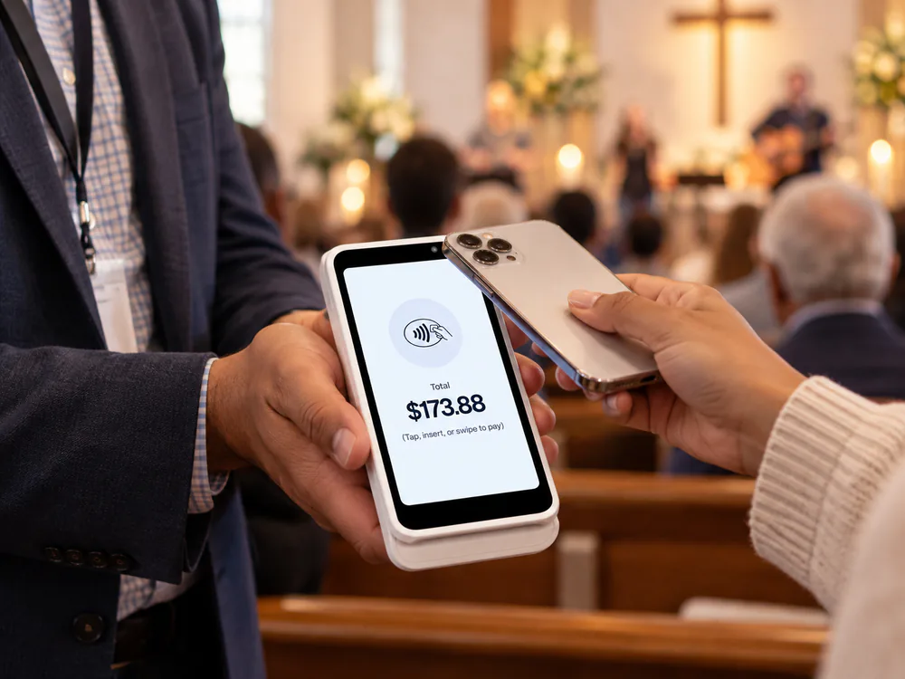 A volunteer holding an S700 handheld with a donation total at a worship gathering